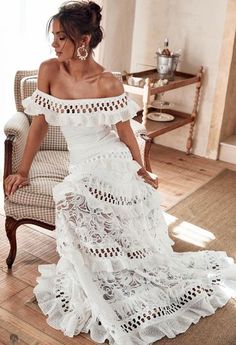 a woman in a white dress sitting on a chair