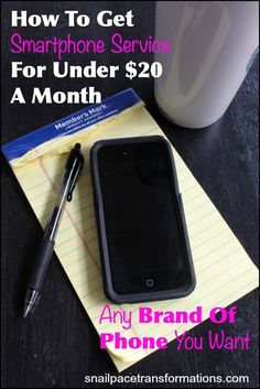 a cell phone sitting on top of a notepad next to a cup and pen