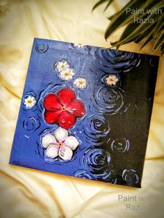 a painting with red and white flowers floating on top of water in front of a palm tree