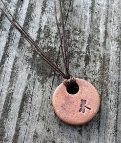 a small ceramic pendant with a cross on it