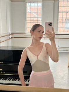 a woman taking a selfie in front of a piano