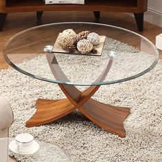 a glass coffee table with wooden accents in a living room