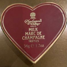 a heart shaped plaque with the words milk marc de champagne truffles on it