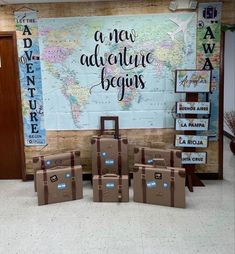 suitcases are lined up in front of a wall with a world map on it