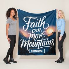 two women holding up a banner that says faith can move mountains and the sun is setting