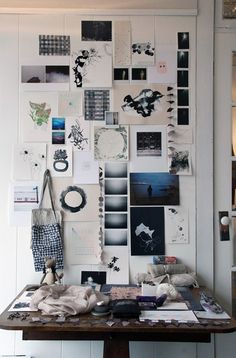 a wooden table topped with lots of pictures and papers on it's side wall