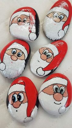 six painted rocks with santa claus faces on them, all in red and white colors