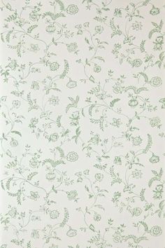 a white wall with green flowers and leaves on it