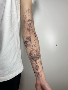 a person with a tattoo on their arm holding onto a hand that has many different things in it