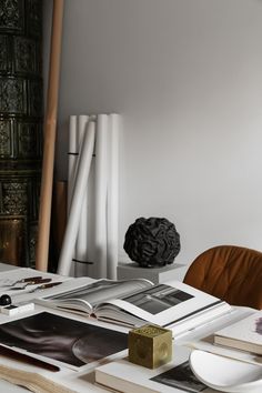 a table topped with books and pictures next to a chair