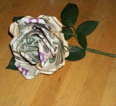 a flower made out of money sitting on top of a wooden floor