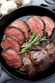 steak in a cast iron skillet with garlic and herbs