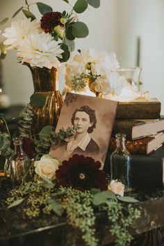 a table topped with books and vases filled with flowers