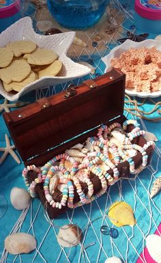 an open trunk sitting on top of a blue table covered in shells and other items