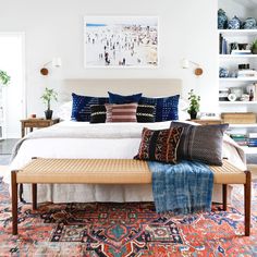 a large bed sitting in the middle of a room with lots of pillows on top of it