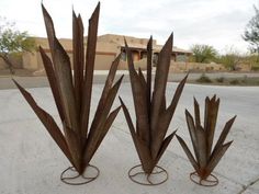 three metal planters sitting in the middle of a street