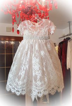 a white dress with red flowers hanging from it