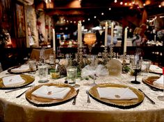 the table is set with plates, silverware and napkins for an elegant dinner