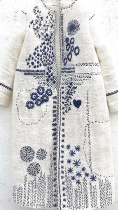 a white sweater with blue flowers and hearts on it