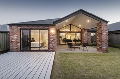 a brick house with an outdoor patio and dining area