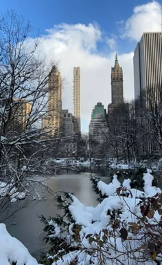 the city skyline is covered in snow and surrounded by tall buildings on either side of a lake