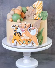 a cake decorated with the characters of disney's lion king