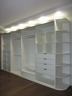 an empty white closet with shelves and drawers