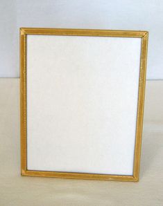 a white and gold frame sitting on top of a table