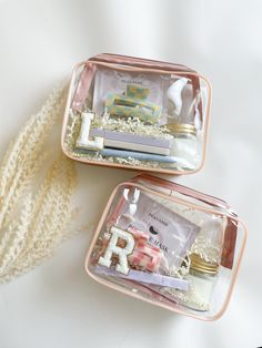 two pink plastic containers filled with items on top of a white tablecloth covered floor