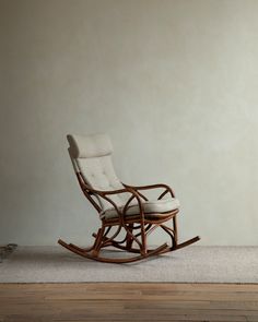 a rocking chair on the floor in front of a wall