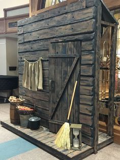 an old wooden shed with brooms and other items