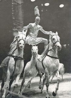 an old black and white photo of two women on horses, one jumping over the other