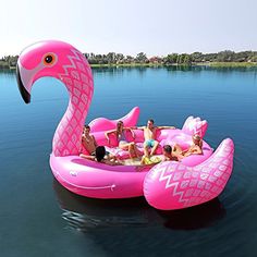 an inflatable pink flamingo float floating on the water with people around it