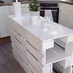 a kitchen island made out of pallet wood with two planters sitting on top