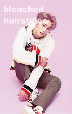 a young man sitting on top of a white and red shoe next to a pink background