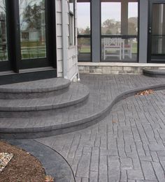 an outdoor patio with steps leading up to the front door