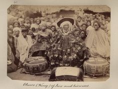 an old black and white photo with many people around it, including a woman in traditional garb