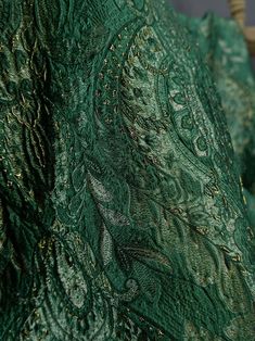 a close up view of the back of a green dress with gold sequins