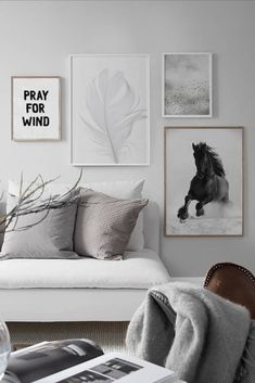 a living room with white walls and pictures on the wall above it, including a couch