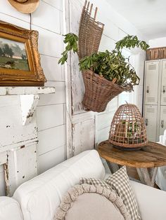 a living room filled with white furniture and lots of greenery on top of it