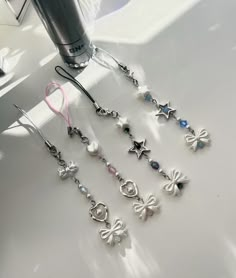 a pair of earrings with pearls and stars hanging from them on a table next to a hair dryer