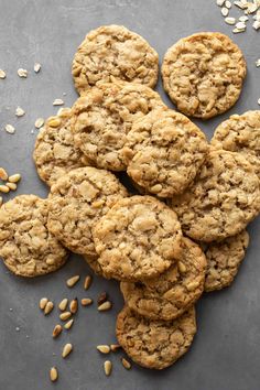 oatmeal cookies on a gray surface with scattered oats around the cookie