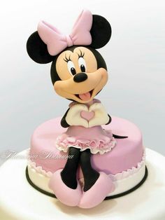 a minnie mouse cake with pink frosting on top