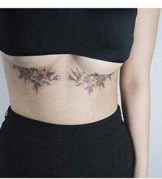 a woman's stomach with flowers and leaves tattooed on the side by an individual