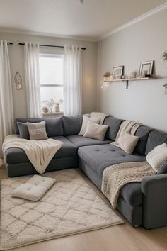 a living room with a gray couch and white rugs on the hardwood flooring