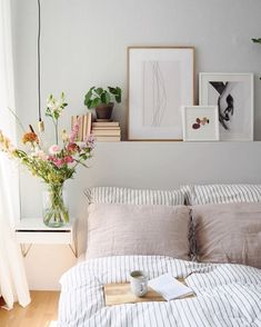 a bedroom with flowers and pictures on the wall above the bed, along with a cup of coffee