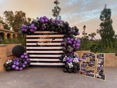 an entrance decorated with purple and black balloons for a 50th birthday party at disney's animal kingdom