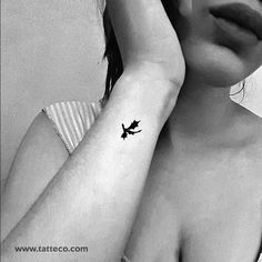 a black and white photo of a woman with a small tattoo on her left arm