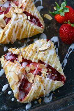 two pastries with strawberries and almonds on top