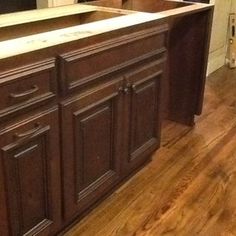 a kitchen with wooden floors and cabinets in it